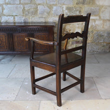 Load image into Gallery viewer, good-colour-early-19th-century-elm-open-armchair-originating-from-north-wales-square-styles-rails-stepped-top-rail-decorative-middle-rail-with-central-roundal-between-two-serpentine-shaped-elements-serpentine-shape-arms-arm-supports-decorative-chair-two-plank-elm-seat-square-legs-united-by-stretchers-wonderful-patina-contrasting-black-golden-honey-colours-particularly-attractive-traditional-contemporary-for-sale-damon-blandford-antiques-stroud-stow-on-the-wold-cotswolds-regional-furniture