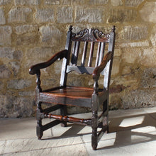 Load image into Gallery viewer, good-late-C17th-English-joined-oak-armchair-slat-back-good-angle-rake-particularly-comfortable-features-highly-decorative-well-carved-crest-rail-shaped-mid-rail-considerable-aesthetic-appeal-down-swept-arms-nicely-turned-supports-boarded-seat-turned-square-legs-stretchers-good-solid-condition-excellent-colour-beautifully-contrasting-black-gold-tones-for-sale-damon-blandford-antiques-stroud-stow-on-the-wold-early-oak-cotswold-country-house