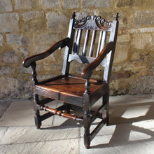 Load image into Gallery viewer, good-late-C17th-English-joined-oak-armchair-slat-back-good-angle-rake-particularly-comfortable-features-highly-decorative-well-carved-crest-rail-shaped-mid-rail-considerable-aesthetic-appeal-down-swept-arms-nicely-turned-supports-boarded-seat-turned-square-legs-stretchers-good-solid-condition-excellent-colour-beautifully-contrasting-black-gold-tones-for-sale-damon-blandford-antiques-stroud-stow-on-the-wold-early-oak-cotswold-country-house