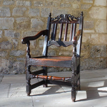 Load image into Gallery viewer, good-late-C17th-English-joined-oak-armchair-slat-back-good-angle-rake-particularly-comfortable-features-highly-decorative-well-carved-crest-rail-shaped-mid-rail-considerable-aesthetic-appeal-down-swept-arms-nicely-turned-supports-boarded-seat-turned-square-legs-stretchers-good-solid-condition-excellent-colour-beautifully-contrasting-black-gold-tones-for-sale-damon-blandford-antiques-stroud-stow-on-the-wold-early-oak-cotswold-country-house