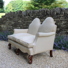 Load image into Gallery viewer, excellent-quality-two-seater-jacobean-revival-settee-generous-proportions-camel-back-scrolled-arms-loose-feather-cushion-seat-pads-shaped-frieze-carved-show-wood-legs-square-swept-legs-rear-beautifully-upholstered-high-quality-cream-green-colour-fabric-piped-edging-english-circa-1900-for-sale-damon-blandford-antiques-cotswolds-seating