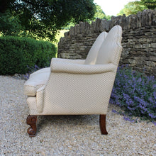 Load image into Gallery viewer, excellent-quality-two-seater-jacobean-revival-settee-generous-proportions-camel-back-scrolled-arms-loose-feather-cushion-seat-pads-shaped-frieze-carved-show-wood-legs-square-swept-legs-rear-beautifully-upholstered-high-quality-cream-green-colour-fabric-piped-edging-english-circa-1900-for-sale-damon-blandford-antiques-cotswolds-seating