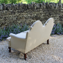 Load image into Gallery viewer, excellent-quality-two-seater-jacobean-revival-settee-generous-proportions-camel-back-scrolled-arms-loose-feather-cushion-seat-pads-shaped-frieze-carved-show-wood-legs-square-swept-legs-rear-beautifully-upholstered-high-quality-cream-green-colour-fabric-piped-edging-english-circa-1900-for-sale-damon-blandford-antiques-cotswolds-seating