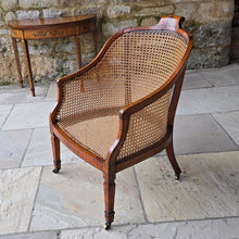 Load image into Gallery viewer, fine-19th-century-adam-style-bergère-arm-chair-generous-wide-deep-proportions-concave-arm-supports-square-tapered-swept-legs-brass-castors-satinwood-frame-painted-neo-classical-design-foliage-flowers-line-decoration-scrolled-crest-rail-young-lady-spaniel-cane-work-seat-back-rest-excellent-original-condition-good-vibrant-colours-excellent-example-aesthetic-appeal-for-sale-damon-blandford-antiques-stow-on-the-wold-cotswolds