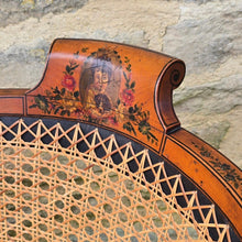 Load image into Gallery viewer, fine-19th-century-adam-style-bergère-arm-chair-generous-wide-deep-proportions-concave-arm-supports-square-tapered-swept-legs-brass-castors-satinwood-frame-painted-neo-classical-design-foliage-flowers-line-decoration-scrolled-crest-rail-young-lady-spaniel-cane-work-seat-back-rest-excellent-original-condition-good-vibrant-colours-excellent-example-aesthetic-appeal-for-sale-damon-blandford-antiques-stow-on-the-wold-cotswolds