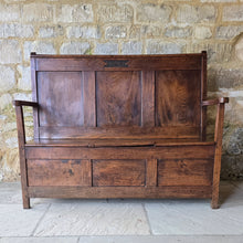 Load image into Gallery viewer, Good-colour-early-19th-century-box-settle-elm-back-rest-with-gentle-rake-three-panels-top-rail-carved-initials-J.I.A.I.-box-storage-section-bench-seat-arm-rests-square-supports-attractive-useful-furniture-hallway-boot-room-welsh-boarders-circa-1800-for-sale-damon-blandford-antiques-stow-on-the-wold-cotswolds