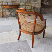 Load image into Gallery viewer, fine-19th-century-adam-style-bergère-arm-chair-generous-wide-deep-proportions-concave-arm-supports-square-tapered-swept-legs-brass-castors-satinwood-frame-painted-neo-classical-design-foliage-flowers-line-decoration-scrolled-crest-rail-young-lady-spaniel-cane-work-seat-back-rest-excellent-original-condition-good-vibrant-colours-excellent-example-aesthetic-appeal-for-sale-damon-blandford-antiques-stow-on-the-wold-cotswolds