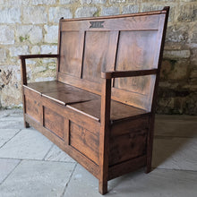 Load image into Gallery viewer, Good-colour-early-19th-century-box-settle-elm-back-rest-with-gentle-rake-three-panels-top-rail-carved-initials-J.I.A.I.-box-storage-section-bench-seat-arm-rests-square-supports-attractive-useful-furniture-hallway-boot-room-welsh-boarders-circa-1800-for-sale-damon-blandford-antiques-stow-on-the-wold-cotswolds