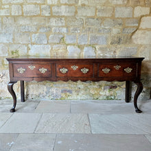 Load image into Gallery viewer, Excellent-quality-colour.mid-18th-century-oak-dresser-base-with-three-plank-top-moulded-edges-three-drawers- equal-length-plain-edges-brass-handles-escutcheons-fretwork-design-shapes-freeze-shapely-cabriole-legs-excellent-condition-for-sale-damon-blandford-antiques-cotswolds