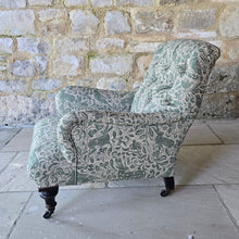 Load image into Gallery viewer, good-excellent-quality-mid-19th-century-armchair-upholstered-chair-shaped-button-back-curved-upholstered-arms-style-of-Howard-&-Sons-ebonised-turned-legs-brass-castors-black-ceramic-wheels-square-swept-legs-rear-incredibly-comfortable armchair-newly-re-upholstered-high-quality-printed-linen-featuring-bird-hare-motifs-attractive-for-sale-low-library-chair-damon-blandford-antiques-stow-on-the-wold-cotswolds