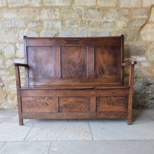 Load image into Gallery viewer, Good-colour-early-19th-century-box-settle-elm-back-rest-with-gentle-rake-three-panels-top-rail-carved-initials-J.I.A.I.-box-storage-section-bench-seat-arm-rests-square-supports-attractive-useful-furniture-hallway-boot-room-welsh-boarders-circa-1800-for-sale-damon-blandford-antiques-stow-on-the-wold-cotswolds