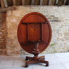 Load image into Gallery viewer, mahogany-tilt-top-table-wonderful-sun-bleached-oval-shape-top-baluster-shaped-pedestal-quadraform-base-damon-blandford-antiques-gloucestershire-cotswolds-for-sale-patina-golds-browns-reds-straw-colours-country-house-interiors-vintage-quality-timbers-breakfast-dinning-table