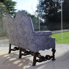 Load image into Gallery viewer, jacobean-revival-settee-exceptionally-good-quality-newly-upholstered-stunning-ludhiana-wool-fabric-intricate-decoration-inspiration-traditional-indian-patterns-features-swirling-floral-design-blue-cream-colourway-seat-completely-re-built-original-horse-hair-seat-pad-feather-cushions-settee-incredibly-stylish-comfortable-carved-parcel-gilt-show-wood-legs-stretchers-foliate-design-statement-piece-english-circa-1900-damon-blandford-antiques-stroud-gloucestershire-interior-design-seating-for-sale