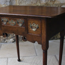 Load image into Gallery viewer, nicely-made-18th-century-provincial-oak-lowboy-three-oak-lined-drawers-cock-beading-original-brass-swan-neck-handles-pierced-back-plates-drawers-decoratively-carved-apron-a-particular-feature-of-this-tableall-raised-on-round-tapering-legs-pad-feet-excellent-colour-condition-north-england-1770-for-sale-damon-blandford-antiques-stroud-gloucestershire-country-house-furniture