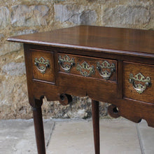 Load image into Gallery viewer, nicely-made-18th-century-provincial-oak-lowboy-three-oak-lined-drawers-cock-beading-original-brass-swan-neck-handles-pierced-back-plates-drawers-decoratively-carved-apron-a-particular-feature-of-this-tableall-raised-on-round-tapering-legs-pad-feet-excellent-colour-condition-north-england-1770-for-sale-damon-blandford-antiques-stroud-gloucestershire-country-house-furniture
