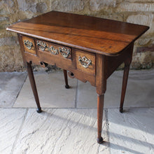 Load image into Gallery viewer, nicely-made-18th-century-provincial-oak-lowboy-three-oak-lined-drawers-cock-beading-original-brass-swan-neck-handles-pierced-back-plates-drawers-decoratively-carved-apron-a-particular-feature-of-this-tableall-raised-on-round-tapering-legs-pad-feet-excellent-colour-condition-north-england-1770-for-sale-damon-blandford-antiques-stroud-gloucestershire-country-house-furniture