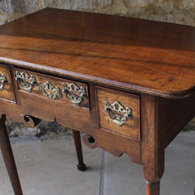 Load image into Gallery viewer, nicely-made-18th-century-provincial-oak-lowboy-three-oak-lined-drawers-cock-beading-original-brass-swan-neck-handles-pierced-back-plates-drawers-decoratively-carved-apron-a-particular-feature-of-this-tableall-raised-on-round-tapering-legs-pad-feet-excellent-colour-condition-north-england-1770-for-sale-damon-blandford-antiques-stroud-gloucestershire-country-house-furniture