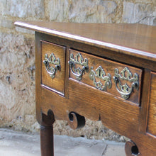 Load image into Gallery viewer, nicely-made-18th-century-provincial-oak-lowboy-three-oak-lined-drawers-cock-beading-original-brass-swan-neck-handles-pierced-back-plates-drawers-decoratively-carved-apron-a-particular-feature-of-this-tableall-raised-on-round-tapering-legs-pad-feet-excellent-colour-condition-north-england-1770-for-sale-damon-blandford-antiques-stroud-gloucestershire-country-house-furniture