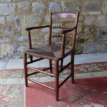 Load image into Gallery viewer, early- 19th- century-rush-seated-open-armchair-excellent-quality-combining-carved-turned-details-shaped-bobbin-carved-mid-rails-shaped-top-rail-circular-styles-wonderfully-shaped-arm-rests-ring-turned-arm-supports-rush-seat-very-comfortable-chair-faux-bamboo-legs-stretchers-excellent-quality-condition-english-circa-1850s-for-sale-damon-blandford-antiques-stow-on-the-wold-stroud-cotswolds-gloucestershire-oxfordshire-interior-decor