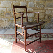 Load image into Gallery viewer, early-19th-century-rush-seated-open-armchair-excellent-quality-combining-carved-turned-details-shaped-bobbin-carved-mid-rails-shaped-top-rail-circular-styles-wonderfully-shaped-arm-rests-ring-turned-arm-supports-rush-seat-very-comfortable-chair-faux-bamboo-legs-stretchers-excellent-quality-condition-english-circa-1850s-for-sale-damon-blandford-antiques-stow-on-the-wold-stroud-cotswolds-gloucestershire-oxfordshire-interior-decor