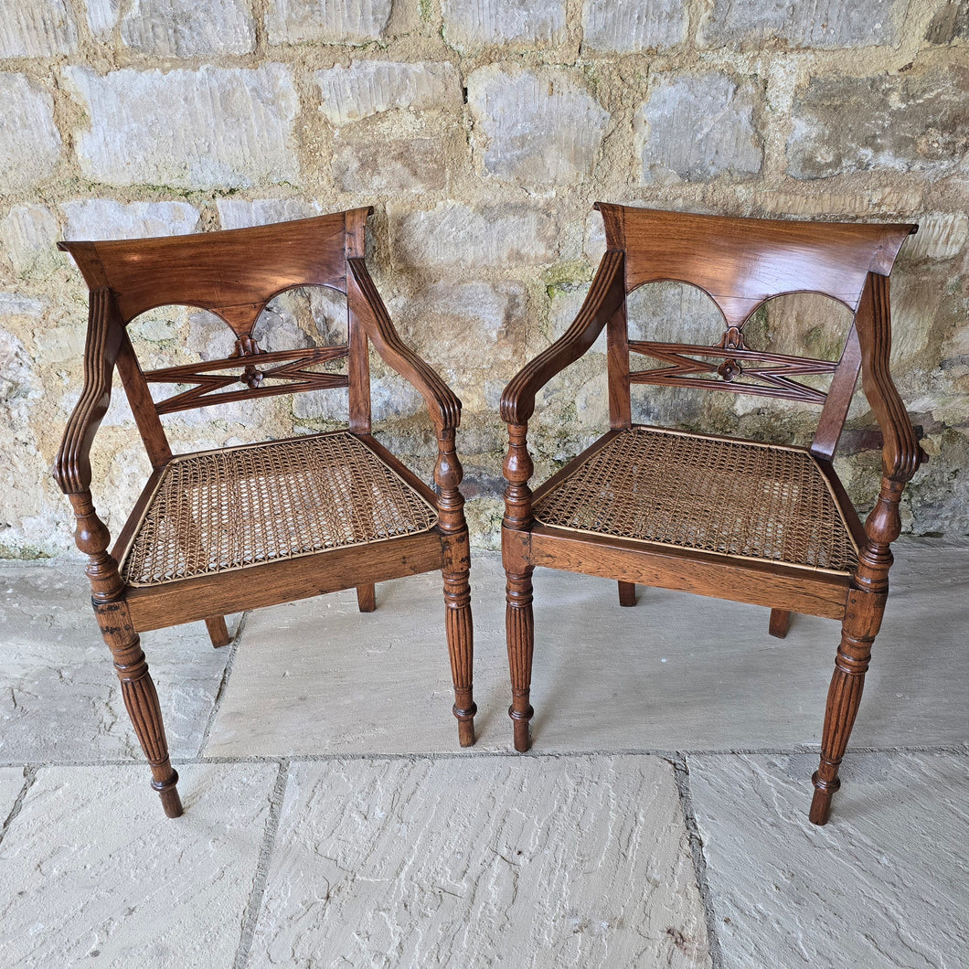 very-attractive-pair-19th-century-anglo-indian-colonial-armchairs-raffles-style-beautifully-hand-carved-teak-back-deep-shaped-crest-rails-scrolled-ends-reeded-mid-rails-down-swept-arms-baluster-shape-supports-caned-seats-fluted-legs-front-square-swept-legs-rear-attractive-comfortable-circa-1850-s-for-sale-damon-blandford-antiques-stow-on-the-wold