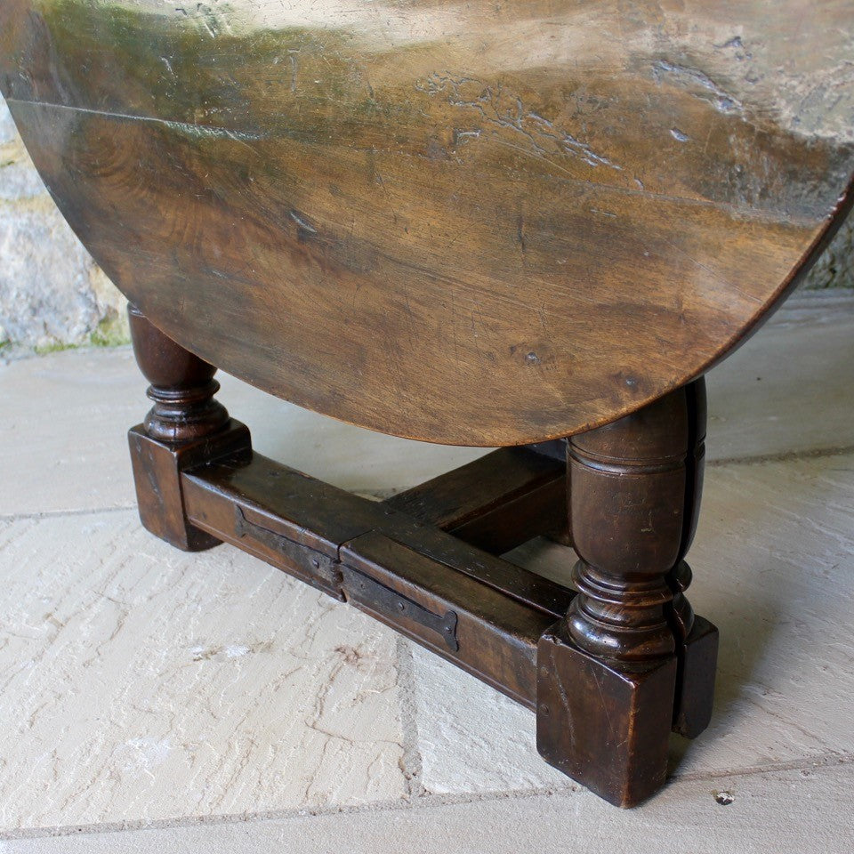 early-18th-century-credence-table-fabulous-patination-three-hundred-years-of-use-oval-shaped-walnut-top-drop-leaf-oak-base-three-baluster-shaped-legs-gate-leg-sanctuary-christian-worship-celebration-eucharist-remembrance-celebration-community-blacksmith-forged-hinges-important-ecclesiastical-furniture-characterful-useful-furniture-very-good-condition-side-occasional-table-english-circa-1725-for-sale-damon-blandford-antiques-stow-on-the-wold-cotswolds