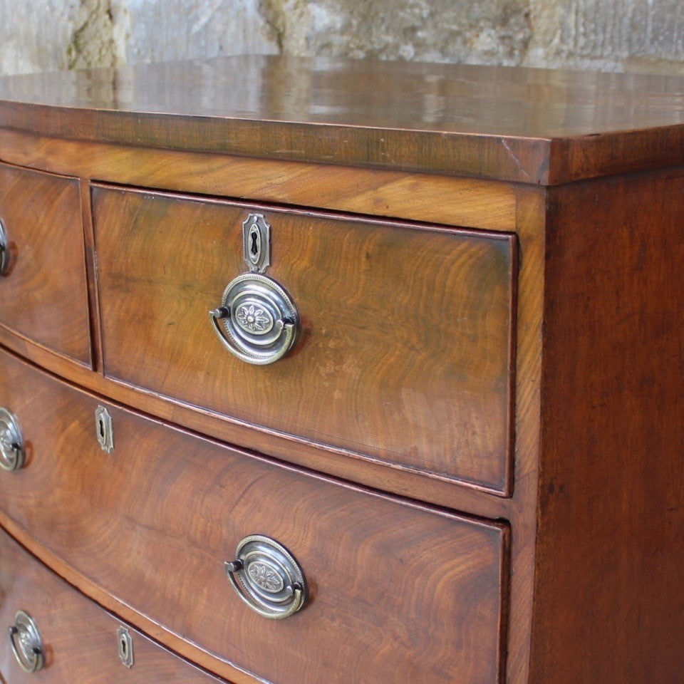 Attractive-early-19th-century-mahogany-bow-fronted-chest-of-drawers-bracket-feet-splayed at-foot-top-cross-banded-satinwood-stringing-two-short-two-long-drawers-cock-beading-drop-handles-drawers-lined-in-mahogany-fine-dovetailing-small-proportions-well-figured-veneer-particular-attractive-for-sale-damon-blandford-antiques-stroud-cotswolds-antique-storage