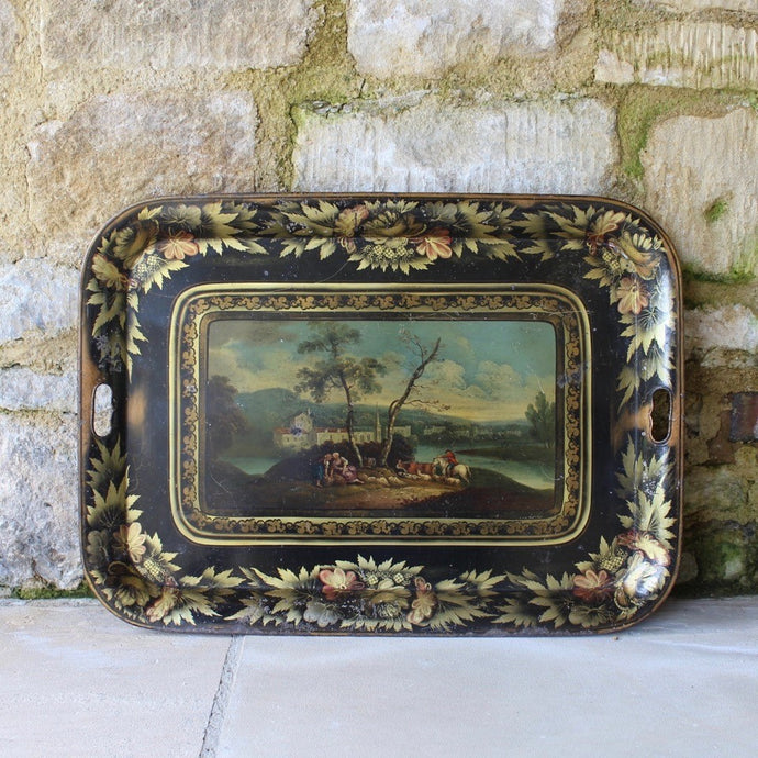 Fine-early-19th-century-toleware-tray-beautifully-decorated-agricultural-workers-sat-under-tree-fore-ground-gentleman-farmer-dog-herding-cattle-horseback-escarpment-middle-ground-lake-buildings-far-bank-wooded-hills-sky-distance-magnificent-scene-black-ground-gilt-decoration-boarder-rim-tray-foliate-design-for-sale-damon-blandford-antiques-stow-on-the-wold-cotswolds-interior-design-fine-antiques