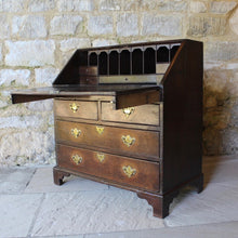 Load image into Gallery viewer, good-quality-18th-century-bureau-constructed-in-oak-fall-front-supported-by-two lopers-bearers-fitted-interior-nine-pigeon-holes-five-small-drawers-concealed-storage-well-two-short-two-long-drawers-dovetail-construction-brass-drop-handles-bracket-feet-highly-original-regional-furniture-excellent-condition-good-colour.-for-sale-damon-blandford-antiques-stow-on-the-wold-cotswolds-antique-strorage
