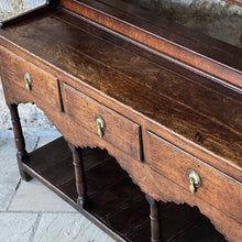 Load image into Gallery viewer, good-colour-georgian-welsh-oak-dresser-with-rack-constructed-from-well-figured-timbers-dresser-comprises-three-drawers-above-cupids-bow-shap- frieze-turned-supports-pot-board-excellent-condition-fresh-to-market-attractive-useful-furniture-south-wales-circa-1790-1810-good-original-condition-for-sale-damon-blandford-antiques-stow-on-the-wold
