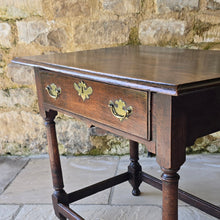 Load image into Gallery viewer, early-george-II-oak-side-table-exceptionally-good-colour-condition-overhung- top-ogee-moulding above-full-width-frieze-drawer-brass-handles-escutcheon-plate-well-turned-gun-barrel-legs-ring-turned-details-feet-outward-edged-stretches-english-circa-1730-for-sale-damon-blandford-antiques-stow-on-the-wold-cotswolds
