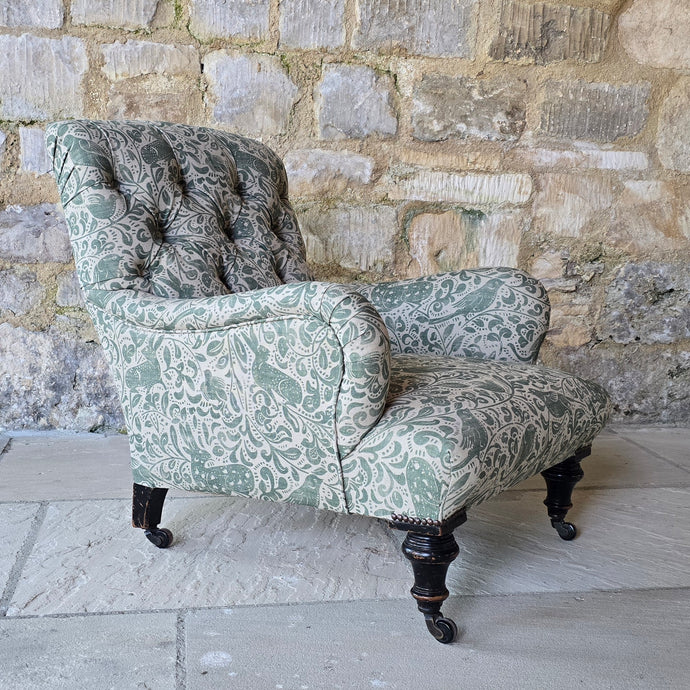 good-excellent-quality-mid-19th-century-armchair-upholstered-chair-shaped-button-back-curved-upholstered-arms-style-of-Howard-&-Sons-ebonised-turned-legs-brass-castors-black-ceramic-wheels-square-swept-legs-rear-incredibly-comfortable armchair-newly-re-upholstered-high-quality-printed-linen-featuring-bird-hare-motifs-attractive-for-sale-low-library-chair-damon-blandford-antiques-stow-on-the-wold-cotswolds
