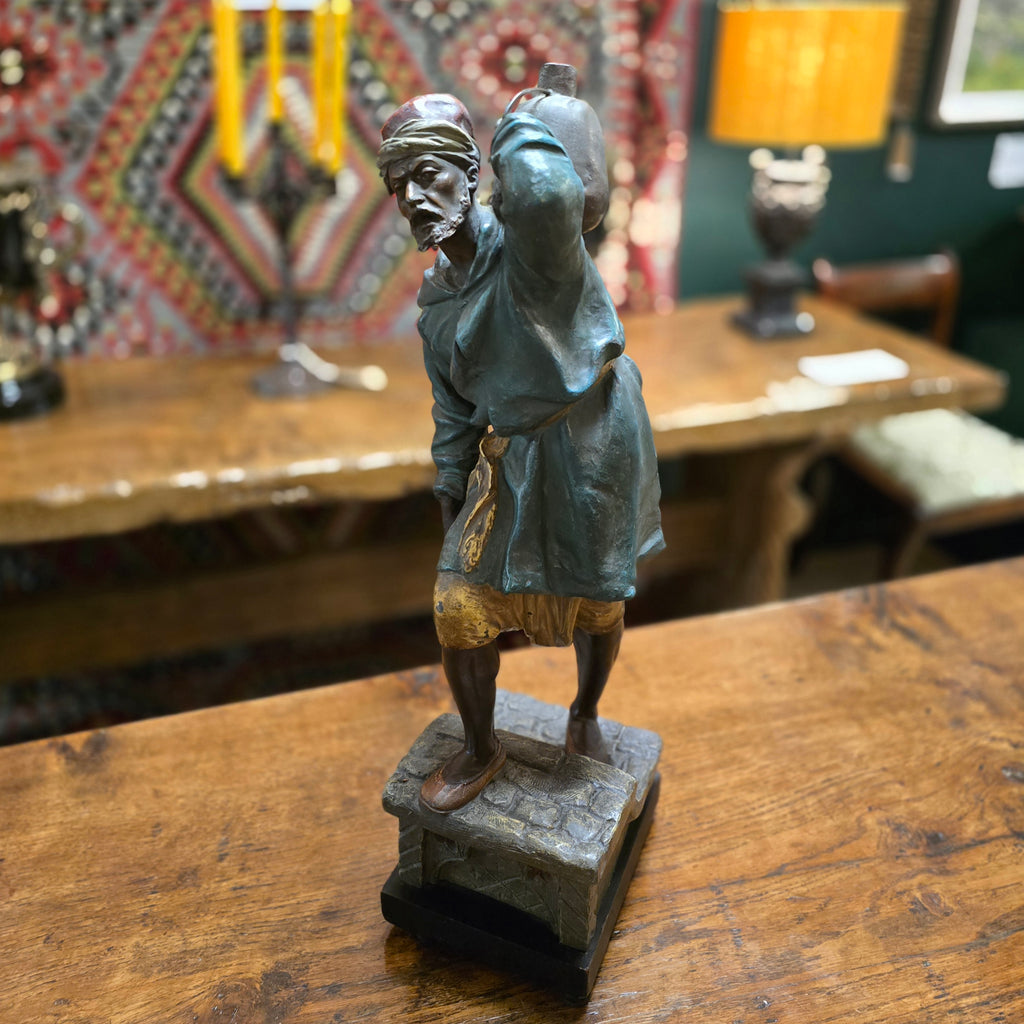 Spelter-casting-sculpture-north-african-moorish-water-carrier-late-19th-early-20th-century-polychrome-painted-spelter-figure-signed-original-ebonised-plinth-excellent-condition-good-colour-arab-male-traditional-clothing-carrying-water-vessel-steps-highly-decorative-interior-design-german-circa-1900-for-sale-damon-blandford-antiques-cotswolds-orientalist