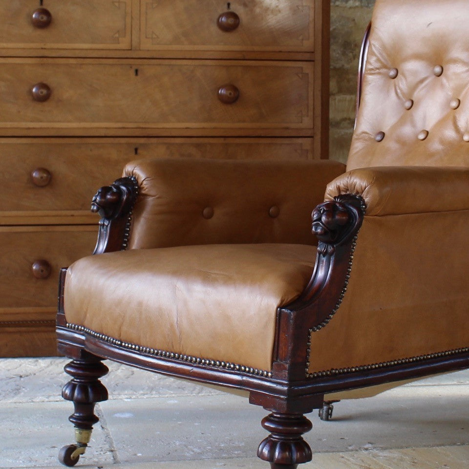 super-shape-leather-library-chair-third-quarter-19th-century-gently-reclining-scrolled-backrest-mahogany show-wood-frame-carved-lion-head-details-contrasting-beautifully-light-brown-tobacco-colour-leather-upholstery-sprung-seat-backrest-raised-well-proportioned-square-swept-legs-rear-turned-carved-legs-front-original-brass-cup-castors-porcelain-wheels-chair-real-presence-grandeur-damon-blandford-antiques-seating-upholstery-gloucestershire-cotswolds-interior-style-decoration-decorative-country-house-for-sale