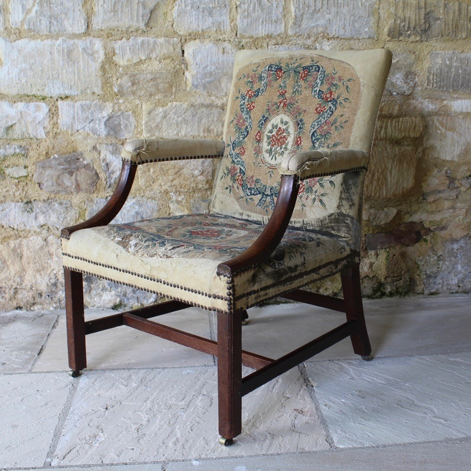 good-18th-century-english-georgian-library-gainsborough-chair-generous-proportions-long-term-private-ownership-square-shaped-back-flanked-upholstered-arms-concave-shaped-mahogany-arm-supports-seat-raised-square-moulded-legs-united-H-shape-stretchers-terminating-original-barrel-castors-covered-19th-century-needlepoint-fabric-french-very-usable-heavily-worn-velvet-needlepoint-fabric-230-years-use-created-time-worn-utterly-charming-virtually-impossible-