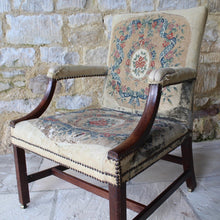 Load image into Gallery viewer, good-18th-century-english-georgian-library-gainsborough-chair-generous-proportions-long-term-private-ownership-square-shaped-back-flanked-upholstered-arms-concave-shaped-mahogany-arm-supports-seat-raised-square-moulded-legs-united-H-shape-stretchers-terminating-original-barrel-castors-covered-19th-century-needlepoint-fabric-french-very-usable-heavily-worn-velvet-needlepoint-fabric-230-years-use-created-time-worn-utterly-charming-country-house-chair-look-english-george-III-Circa-1790-damon-blandford-antiques
