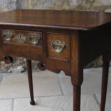 Load image into Gallery viewer, nicely-made-18th-century-provincial-oak-lowboy-three-oak-lined-drawers-cock-beading-original-brass-swan-neck-handles-pierced-back-plates-drawers-decoratively-carved-apron-a-particular-feature-of-this-tableall-raised-on-round-tapering-legs-pad-feet-excellent-colour-condition-north-england-1770-for-sale-damon-blandford-antiques-stroud-gloucestershire-country-house-furniture

