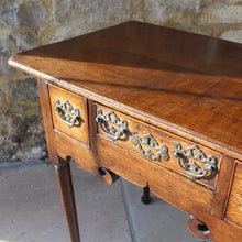 Load image into Gallery viewer, nicely-made-18th-century-provincial-oak-lowboy-three-oak-lined-drawers-cock-beading-original-brass-swan-neck-handles-pierced-back-plates-drawers-decoratively-carved-apron-a-particular-feature-of-this-tableall-raised-on-round-tapering-legs-pad-feet-excellent-colour-condition-north-england-1770-for-sale-damon-blandford-antiques-stroud-gloucestershire-country-house-furniture
