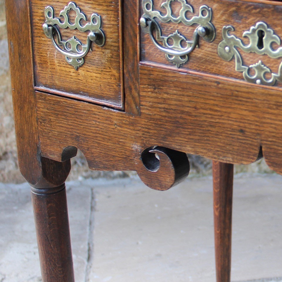 nicely-made-18th-century-provincial-oak-lowboy-three-oak-lined-drawers-cock-beading-original-brass-swan-neck-handles-pierced-back-plates-drawers-decoratively-carved-apron-a-particular-feature-of-this-tableall-raised-on-round-tapering-legs-pad-feet-excellent-colour-condition-north-england-1770-for-sale-damon-blandford-antiques-stroud-gloucestershire-country-house-furniture