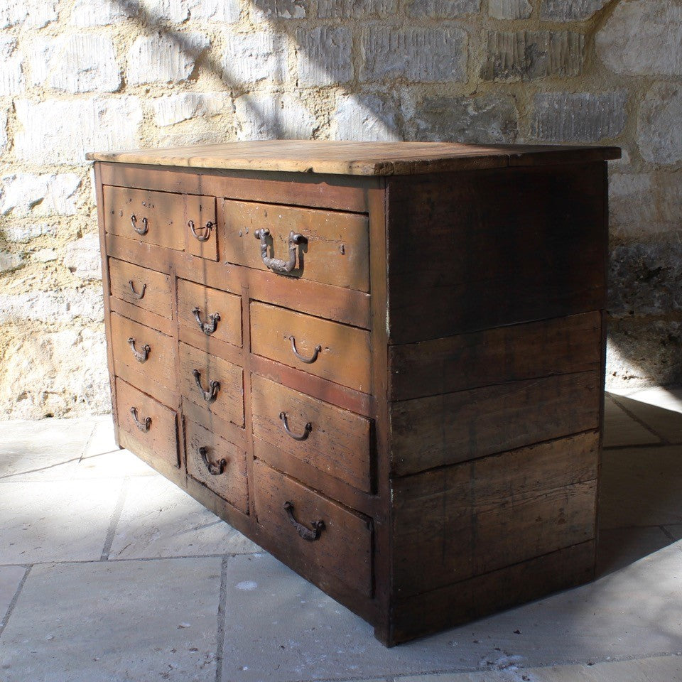 very-rustic-19th-century-bank-of-twelve-drawers-constructed-of-painted-pine-metal-drop-handles-decorative-foliate-design-drawers-retaing-original-planked-pine-top-back-boards-truly-wonderful-appearance-commercial-use-furniture-tremendous-aesthetic-appeal-for-sale-damon-blandford-antiques-storage-stroud-stow-on-the-wold-gloucestershire-cotswolds